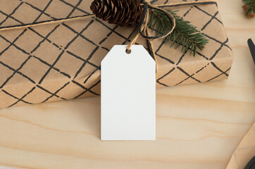 Poster - White blank tag mockup isolated on a kraft christmas gift.