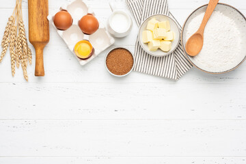 Wall Mural - Ingredients for baking on white wooden table background. Cooking process. Top view copy space