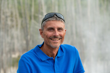 Canvas Print - Portrait of happy caucasian male tourist smiling in front of camera outdoor