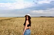 © Helen - Young happy beautiful slender girl with long hair and a hat in a wheat field. Summer landscape