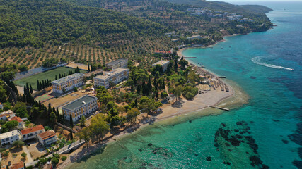 Aerial drone photo of organised with sun beds emerald beach of Kaikia in Ligoneri area near old town of Spetses island, Saronic gulf, Greece