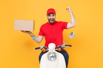 Wall Mural - Delivery man in red cap tshirt uniform driving moped motorbike scooter hold cardboard box isolated on yellow background studio Guy employee working courier Service quarantine pandemic covid-19 concept