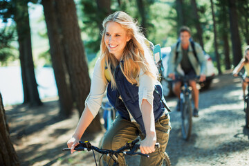 Wall Mural - Smiling woman bike riding in woods