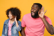 Curious African American Guy Girl Brother Sister In Denim Pink Clothes Isolated On Yellow Background Studio Portrait. People Lifestyle Concept. Mock Up Copy Space. Try To Hear You Listening Intently.