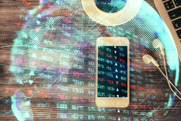 Double exposure of business theme hologram over desktop with phone. Top view. Mobile international trade connection concept.