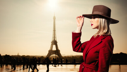  girl in red coat and vintage hat with Parisian Eiffel tower on background.