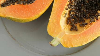 Wall Mural - Ripe half cut papaya fruit. Rotate on plate