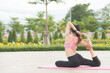 © teerasak - back view. Young women do yoga outdoors on stone. women exercising yoga in the park. Young girl meditating in lotus posture closeup.