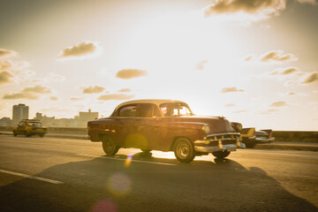 Vintage cars on the Melecon, Havana at sunset