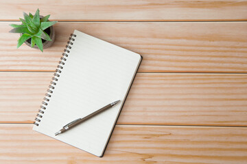 Wall Mural - Top view of Notebooks, pens, glasses, cactus  on wooden desks with sunlight and copy space