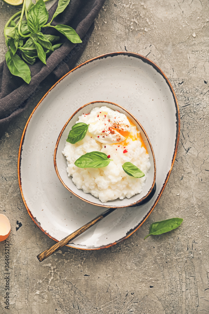 Bowl with boiled rice and egg on grey background