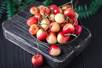 Fresh cherry in a Cup on a dark rustic wooden table. Background with space for copying. Selective focus.