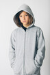 © Jordi Salas - Eleven years old boy with hooded sweater standing against a white background