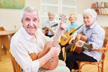 Wall Mural - Senior als Gitarrenlehrer mit anderen Senioren in einem Gitarrenkurs der VHS