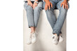 © LIGHTFIELD STUDIOS - cropped view of couple in jeans sitting on cube isolated on white