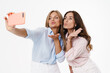 © Drobot Dean - Image of two women blowing air kiss and taking selfie on cellphone