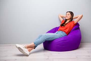 Sticker - Full length body size view of her she nice attractive lovely cute cheerful cheery straight-haired girl sitting in bag chair resting in room light gray pastel color wall