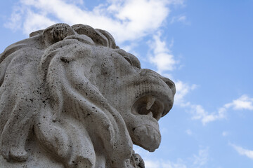 A stone statue of a lion with the sky behind it