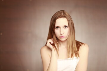 Wall Mural - Emotional girl portrait on the brown background