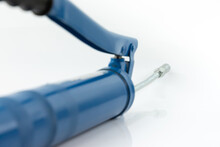 Steel Spout Of Blue Grease Gun On White Background.