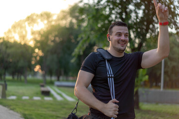  Attractive Man walking in a park after workout, wearing sport bag.