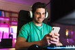 © Drobot Dean - Image of caucasian smiling man using cellphone playing video game