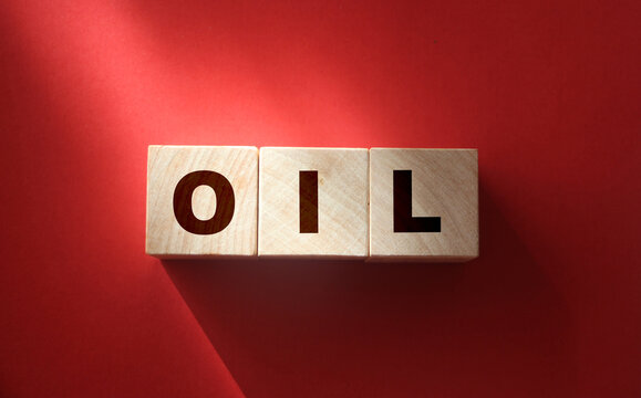 word OIL on cube blocks on red. World Economics business concept