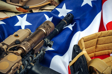 U.S. battle flag and assault rifle on the wooden table.