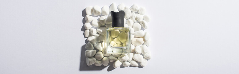 Wall Mural - top view of home perfume in bottle on square made of stones on white background, panoramic shot