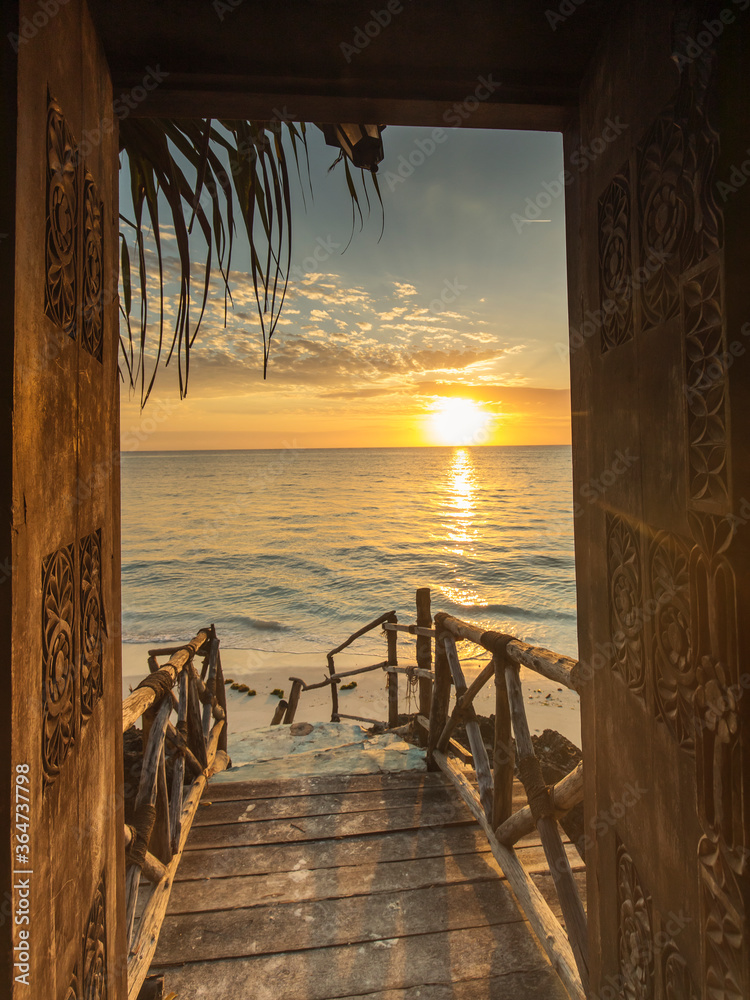 Beautiful dor way to white beach with sunrise in background. Zanzibar - obrazy, fototapety, plakaty 