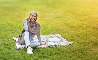 Wall Mural - Positive muslim woman spending weekend at park