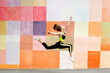 Fitness sport young girl in sportswear doing yoga fitness exercise on a wall background. Sporty gymnast child preteen running training outdoor