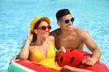 Poster - Happy couple with inflatable ring in swimming pool. Summer vacation