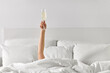© Syda Productions - alcohol, celebration and morning concept - hand of young woman lying in bed with champagne glass