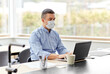 © Syda Productions - quarantine, remote job and pandemic concept - middle-aged man wearing face protective medical mask for protection from virus disease with laptop computer working at home office