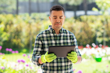 Wall Mural - gardening, technology and people concept - middle-aged man with tablet pc computer at summer garden