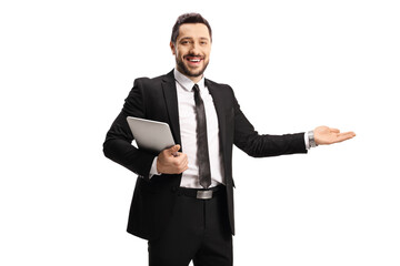 Smiling businessman holding a tablet and gesturing welcome with hand