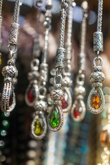 Sticker - Vertical shot of pendants with colorful gemstones under the lights with a blurry background