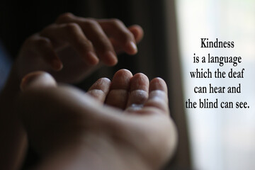 Inspirational quote - Kindness is a language which the deaf can hear and the blind can see. With two hands closeup showing kindness, love and care . Kindness and helping hands in abstract concept.