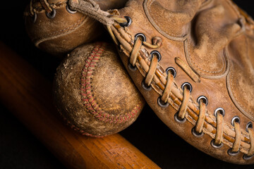 Catchers mitt with old baseball and bat.