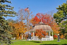 White Gazebo Surrounded By Autumn Colors In A City Park In New England