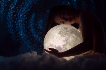 Wall Mural - female magic, astronomy and the zodiac. a beautiful girl holds the moon against the background of st