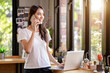 © PK Studio - Asian woman or a happy student smiles on a desk with a computer.