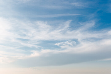 Wall Mural - white clouds stretched across the blue sky on a warm sunny day
