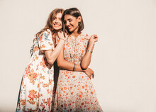 Two Young Beautiful Smiling Hipster Girls In Trendy Summer Sundress.Sexy Carefree Women Posing Near Wall On The Street Background. Positive Models Having Fun And Hugging