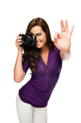 Excelent Shoot! Young beautiful woman photographer taking images with digital camera isolated on white. Focus on hand.