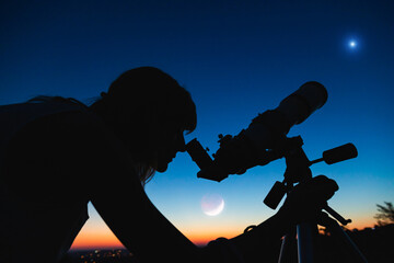 Wall Mural - silhouette of a woman and telescope with twilight sky.