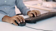© Arnav Pratap Singh - Closeup of Indian businessman typing on keyboard and scrolling mouse at desk in office