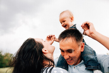 Wall Mural - A happy family walks with a child in nature