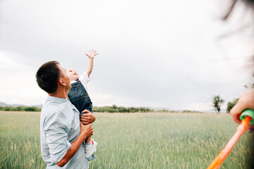 Wall Mural - A happy family walks with a child in nature